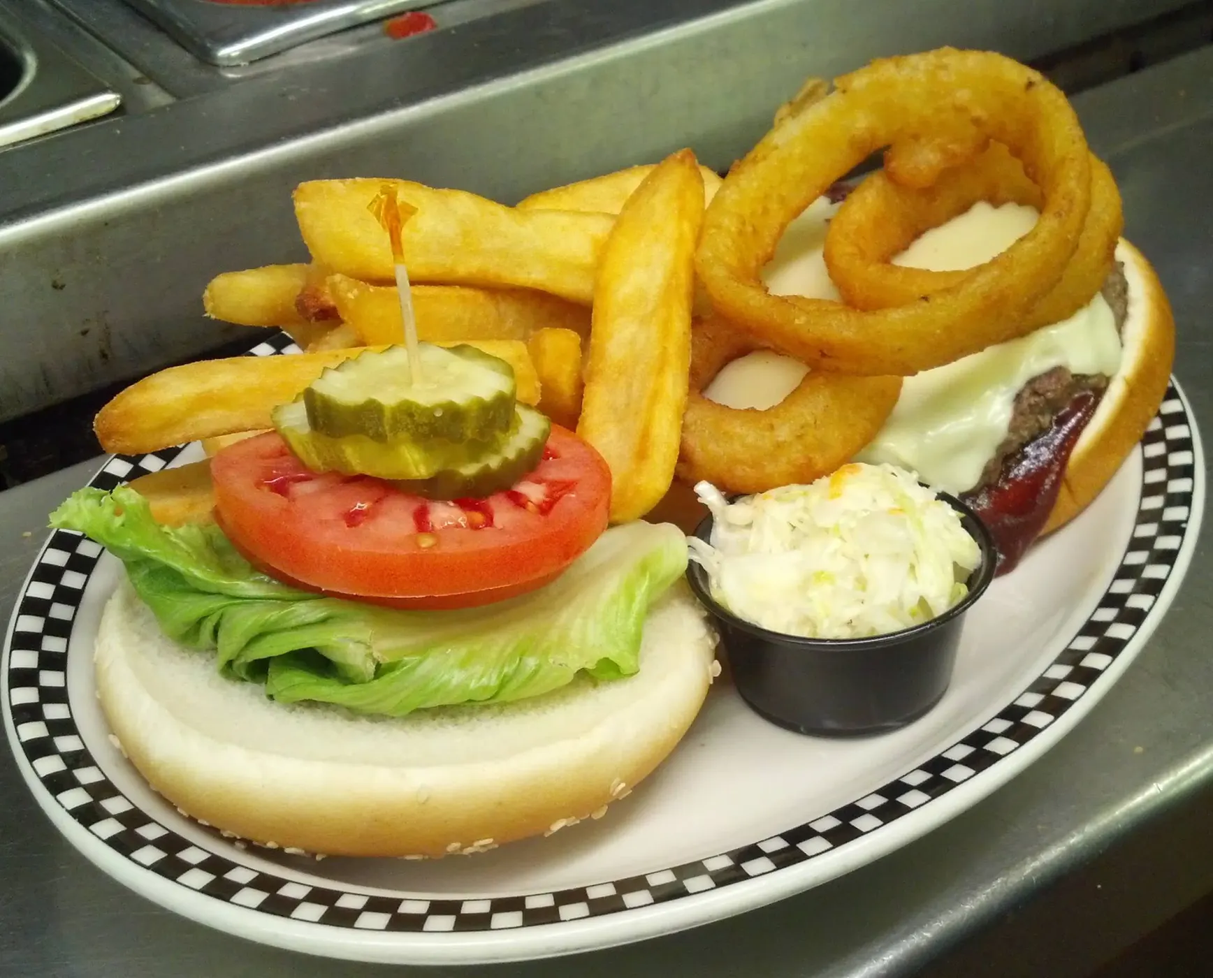 A Silver Coin burger with thick-cut fries on a checkered plate